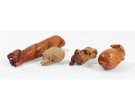A Japanese wood netsuke of a seal with her pup, signed, 6.5cm, a grass hopper on a leaf and two other wooden carvings (4). 