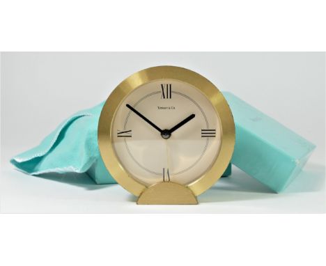 Tiffany &amp; Co. a gilt brass circular quartz alarm clock, number 205738, diameter 88mm, pouch and box. 