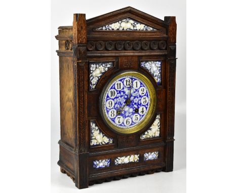 An Aesthetic Movement French oak mantel clock, the ceramic dial set with Arabic numerals in cartouches, on blue ground with p
