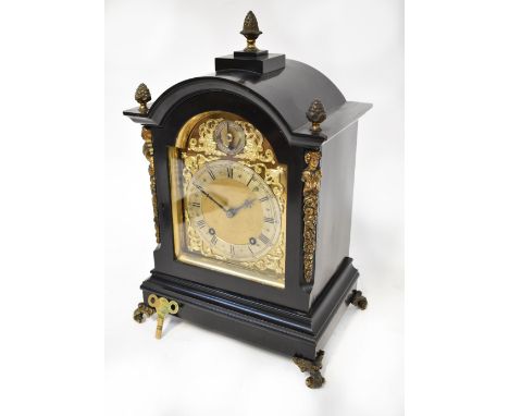 An early 20th century eight day bracket clock in ebonised and ormolu case with pineapple finials to either side and figural d