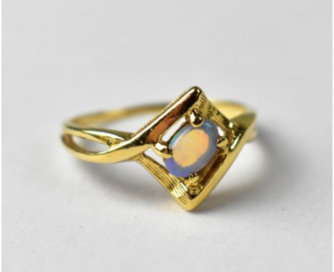 A 14ct gold crossover ring set with opal, approx 2.2g. CONDITION REPORT Surface scratches to the gold and to the opal.