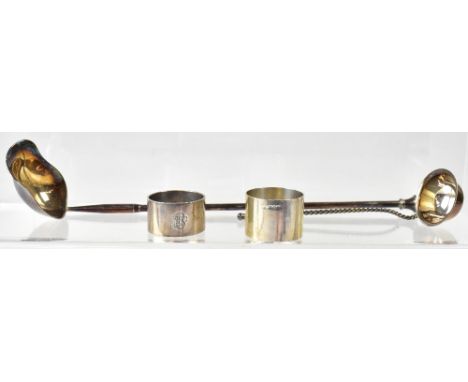 Two non-matching hallmarked silver napkin rings, marks rubbed, a white metal ladle with wrythen stem, and one other white met