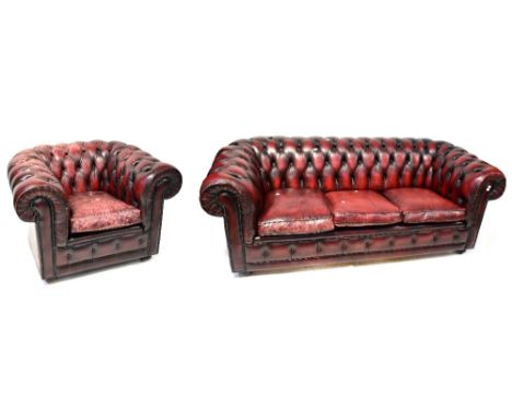 A three-seat Chesterfield settee, button back and upholstered in oxblood leather, width 209cm, and a matching armchair, width