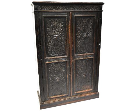 A late 17th century Flemish cabinet, carved scroll top-rail over two twin panel doors, each carved with a man and lion mask h