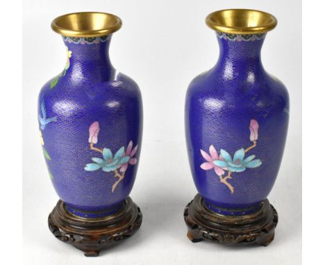 A collection of modern Chinese cloisonné vases and stands to include a pair of blue enamel baluster vases with flared necks a