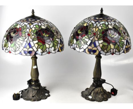 A pair of Tiffany-style table lamps, metal base with spreading Art Nouveau style floral decoration, each with multicoloured o