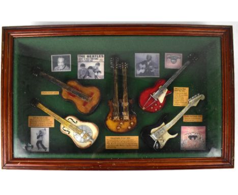 Five model electric guitars, with prints of the musicians who would have used the originals and details of the guitars, frame