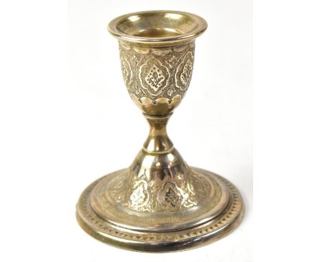 A white metal candlestick with chaste decoration in the Indian style to spreading stepped circular base, marks to base, heigh