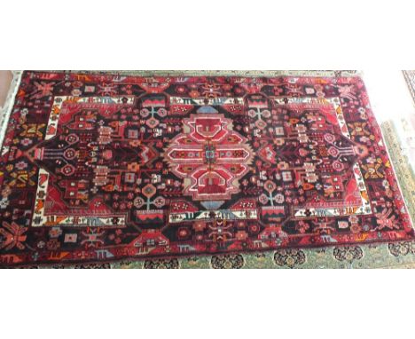 A Persian red ground carpet, 124" x 64"