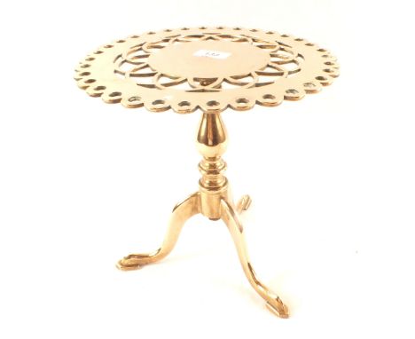 A heavy 19th Century brass trivet in the form of a tripod table with pierced circular top, 12" high