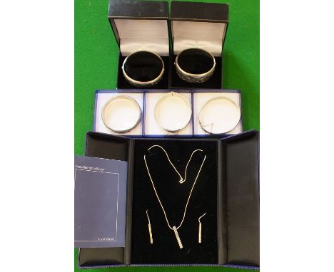 A mixed silver jewellery lot to include five silver bangles of various designs and a silver ingot pendant on chain