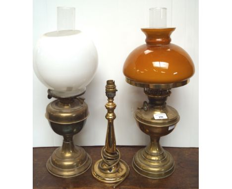 Two brass oil lamps and another light