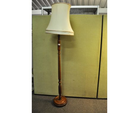 A 20th century turned wood standard lamp, having a shade atop a round plinth base, 184cm high