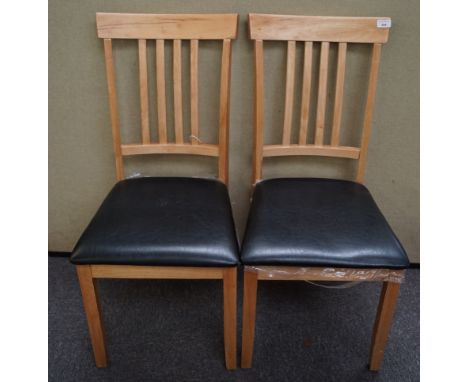 A pair of light wood dining chairs with black seats, 92cm high