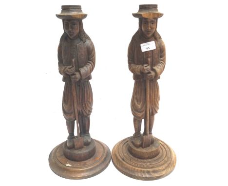 A pair of carved figures, each holding a spade