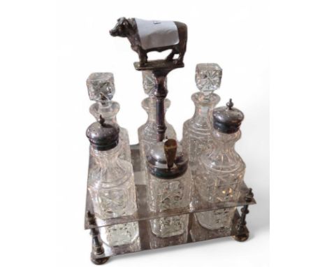 A late 19th or early 20th century silver plated cruet stand, the handle decorated with a bull finial, complete with cut glass