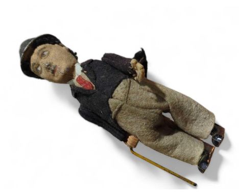 An early 20th century tinplate clockwork toy of Charlie Chaplin, unmarked but probably by Schuco, in felt outfit, his walking