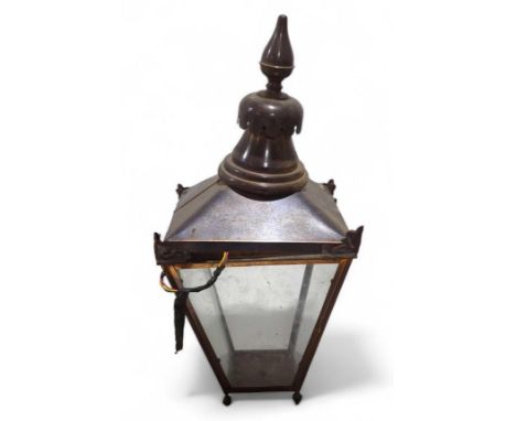 A copper outdoor lantern light fitting, with four glazed sides, and shaped finial to the top, approximately 70cm high (max)