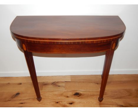 A George III boxwood strung mahogany D shaped folding card table, with baize lined interior on square tapered legs. W. 92cm