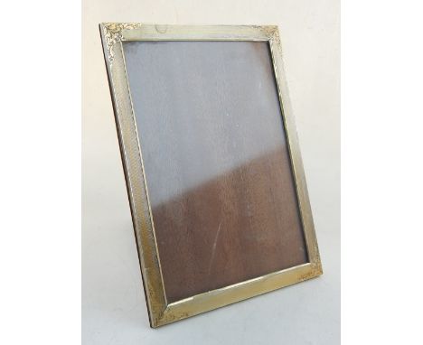 A white metal mounted picture frame, stamped 800, engine turned with foliate spandrels. H. 27cm