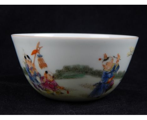 A Chinese tea bowl, study of children playing musical instruments in a procession, six blue character marks to base. D. 8.3cm