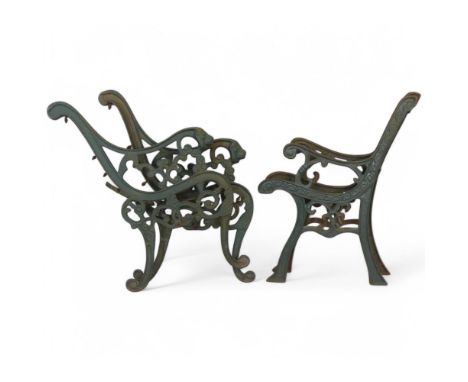 Two pairs of painted cast iron bench ends, one pair with lion mask decoration. Largest, width 60cm, height 78cm.
