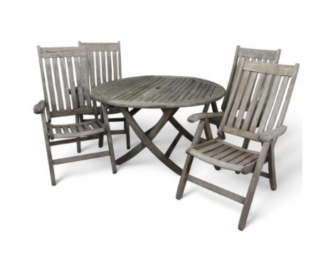 NOVA FURNITURE - A weathered teak circular folding garden table, diameter 130cm, height 72cm, with four matching chairs.Good 