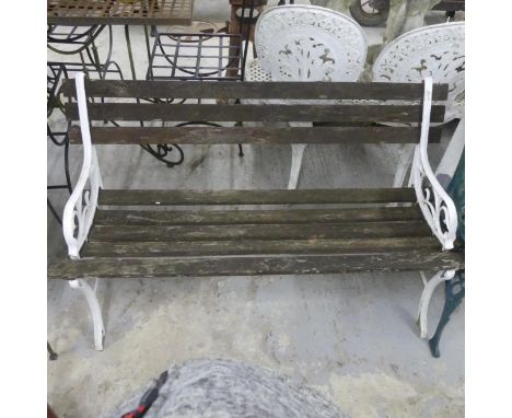 A weathered teak slatted garden bench with painted cast metal ends. length 122cm, Height 68cm, Depth 57cm.
