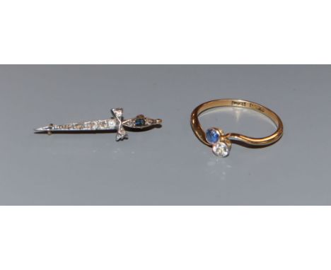 An early 20th century 18ct, two stone sapphire and diamond crossover ring and a similar sapphire and diamond set dagger brooc