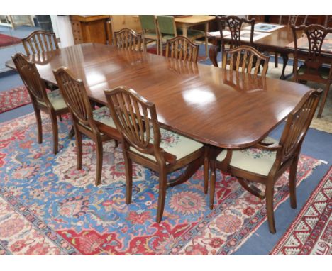 A set of 8 Hepplewhite style mahogany dining chairs and a Regency mahogany two pillar dining table, with one spare leaf Table