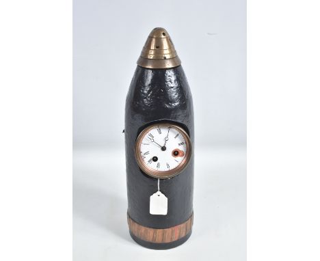 A TRENCH ART MANTLE CLOCK FORMED FROM A BOMB CASING, 19th century movement free from the case, damaged dial, roman numerals, 