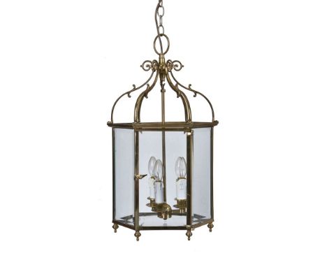 A pair of gilt metal and glazed hexagonal hall lanterns in George III taste, modern, each with six scrolling supports rising 