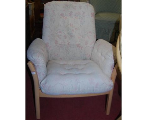An contemporary Ercol light elm and floral cushion upholstered armchair
