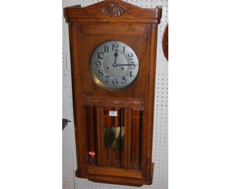 A 1930s oak drop trunk wall clock