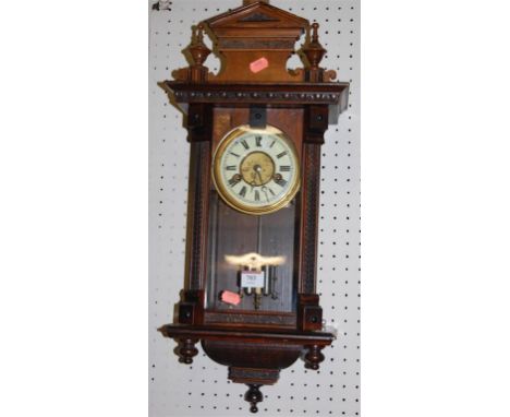An early 20th century walnut drop trunk wall clock