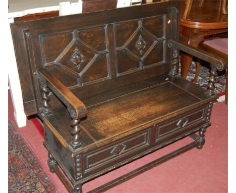 An early 20th century geometric moulded oak fold-over monks bench having typical hinged box seat base