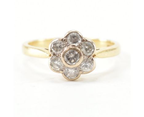 A hallmarked 18ct yellow gold &amp; diamond cluster ring. The ring having a central round cut bezel set diamond surrounded by