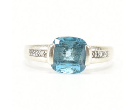 A hallmarked 9ct white gold, topaz &amp; diamond ring. The ring having a bar claw set square cut blue topaz to accent diamond