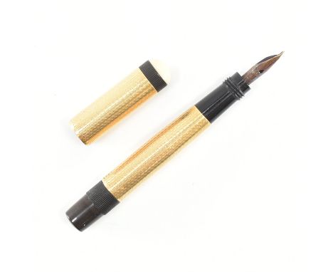 An Art Deco 18ct gold mini fountain pen. The pen having engine turned decoration to the body and lid. The pen having a twist 