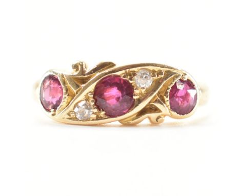 A hallmarked ruby and diamond ring. The ring set with three round cut rubies flanked by two round brilliant cut diamonds. Hal