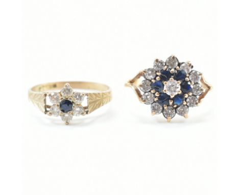 Two hallmarked 9ct gold cluster rings. A ring set with a central CZ framed by sapphires and further circle of CZs. to bifurca