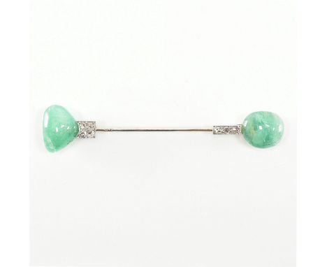 An Art Deco emerald and diamond Jabot pin. The pin having two shaped emerald cabochons set with old cut diamonds in the form 