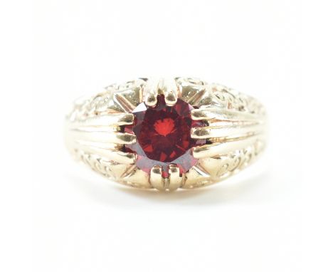 A hallmarked 9ct yellow gold &amp; red stone solitaire ring. The ring having a round cut red stone to buttercup claw setting 