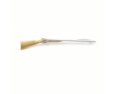 A hallmarked 9ct bi colour gold shotgun brooch pin. The two tone gold brooch depicting a hunting firearm gun, the barrel of w