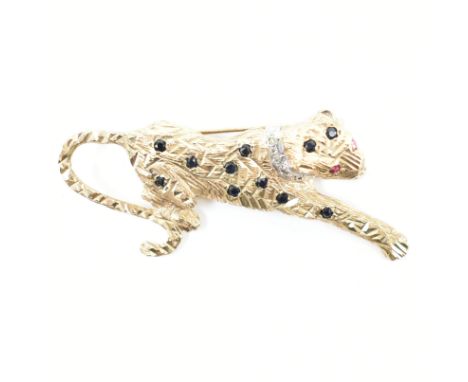 A hallmarked 9ct yellow gold, diamond, sapphire &amp; ruby leopard brooch pin. The brooch in the form of a prowling leopard w