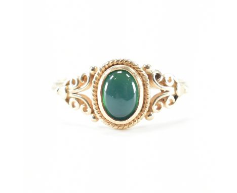 A hallmarked 9ct yellow gold &amp; green stone solitaire ring. The single stone ring having a central oval cut bezel set gree