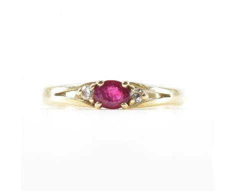 A vintage 14ct yellow gold, ruby &amp; white stone ring. The ring having a central oval cut ruby flanked by a round cut white