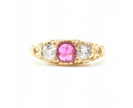 A hallmarked Victorian 18ct gold ruby and diamond three stone ring. The ring set with a central ruby flanked by two old cut d