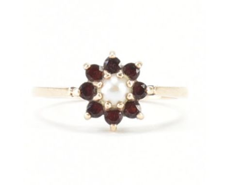 A hallmarked 9ct rose gold, garnet &amp; pearl cluster ring. The ring having a central prong set pearl surrounded by a halo o