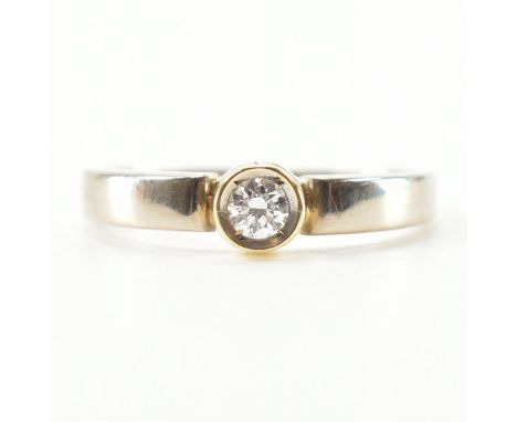 A 14ct gold diamond solitaire ring. The ring having a bezel set round brilliant cut diamond to tapering shank. Estimated diam